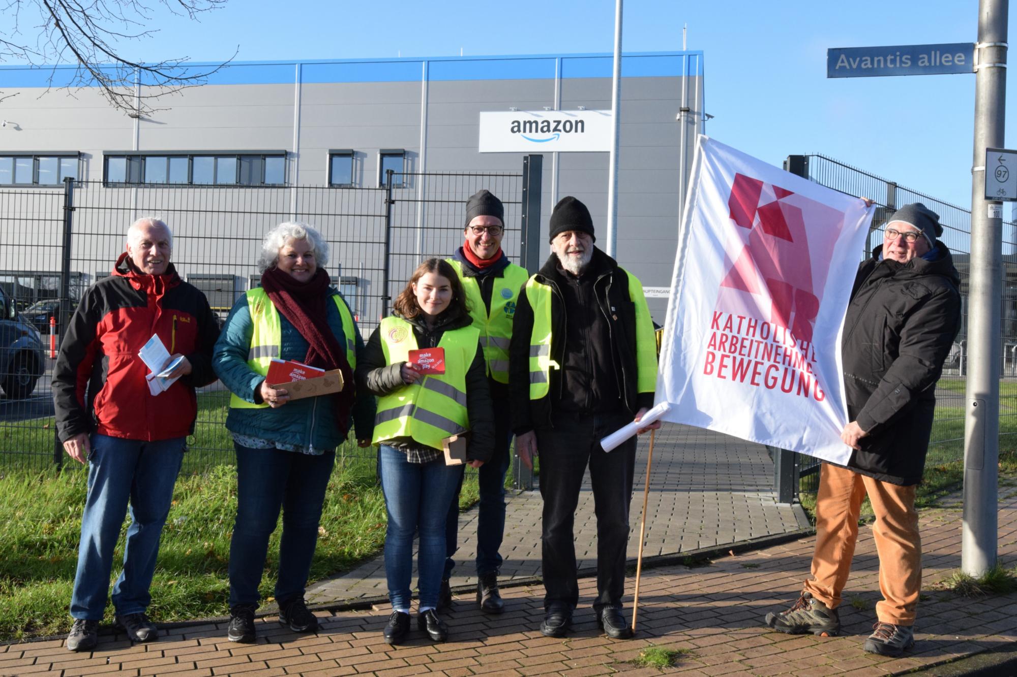 Vereinte Solidarität zum Black Friday 2022 vor dem Amazon-Verteilzentrum im Gewerbegebiet zwischen Aachen und Heerlen. Von links nach rechts: Heinz Backes, Ursula Rohrer, Anna Schlecht, Dr. Manfred Körber, Andris Gulbins und Hans-Werner Quasten.